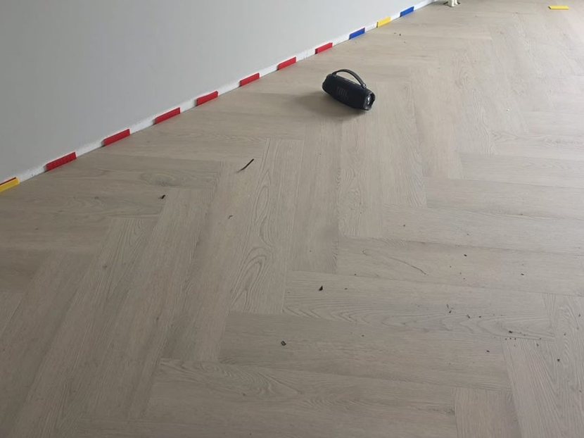 Lichte PVC visgraatvloer met een nette aansluiting langs de wand