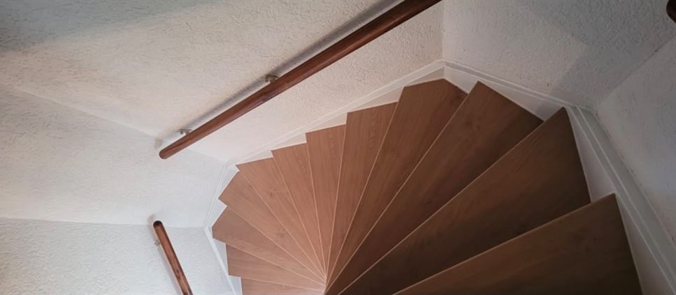 Gedraaide trap met lichte houten overzettreden, na de renovatie
