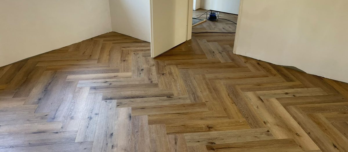 Pas gelegde visgraatvloer in warm eiken in een woonkamer