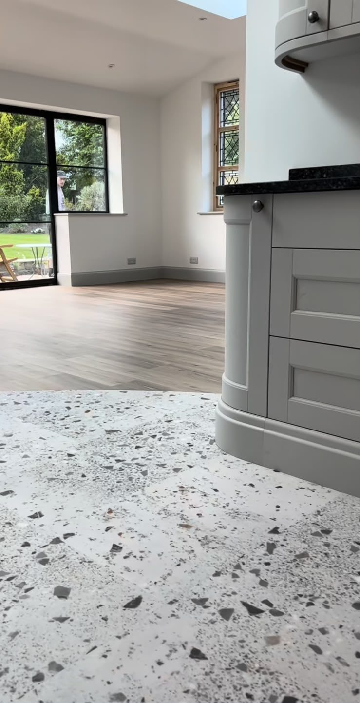 Lichte plankvloer in het woongedeelte, aansluitend op de terrazzovloer van de keuken