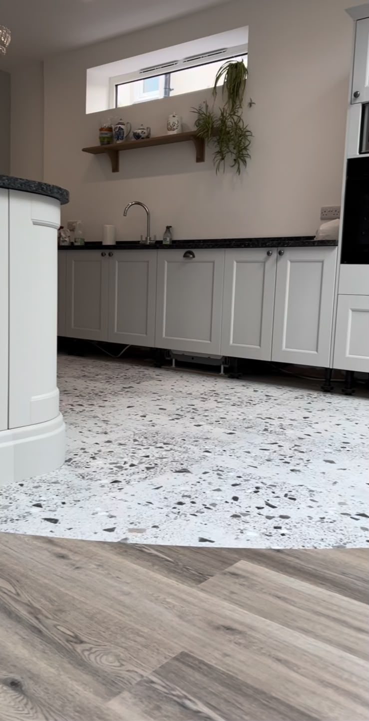 Overgang tussen terrazzo en plankvloer langs het keukenblok